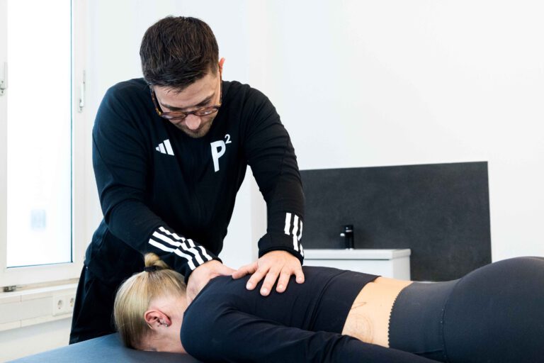 Physiotherapeut behandelt den Rücken einer Patientin bei P² Physio Neuss